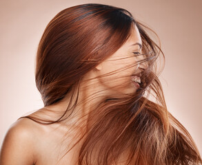 Naklejka premium Shaking hair, beauty and cosmetics of a happy woman on studio background for luxury keratin treatment with shampoo product. Headshot of female posing for salon, hairdresser and wellness mockup