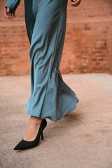 Someone walking with heels and elegant dress on the street
