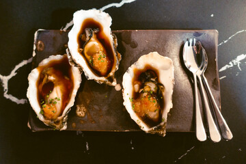 oysters on their shell prepared to be eaten on a plate