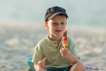 Little boy eating ice cream on the beach on vacation. Summer holidays near the see. Close up