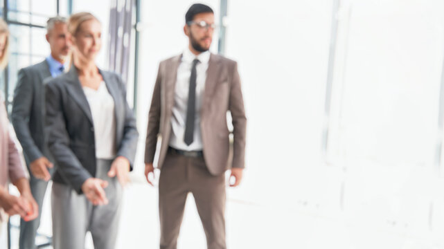 blurry image of a business team standing in an office. background image of a group of corporate employees in the office lobby