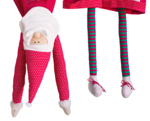 A New Year's soft toy in a red cap and with a beard hangs upside down. Christmas decor in striped tights, Santa claus dangles on a rope