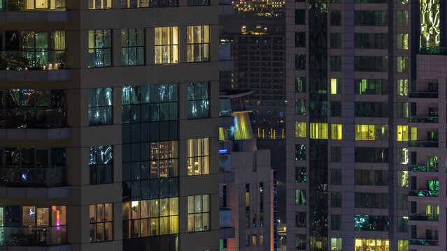 Evening view of exterior apartment recidential building timelapse with glowing panoramic windows. High rise illuminated skyscraper with lights