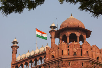 Red Fort Lal Qila with Indian flag flying. Delhi, India. Tricolor Flag of India with Sky in Background	
