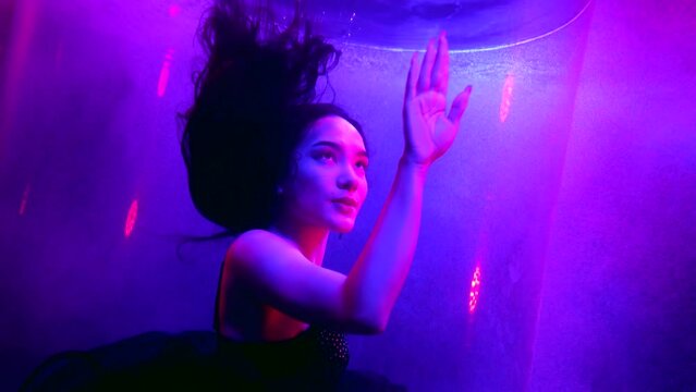 portrait of beautiful asian woman in mysterious depth of pool, amazing art lights, pink and blue
