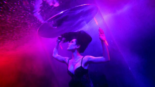mysterious busty woman swimming in pool depth with amazing pink and blue lights, beautiful sexy lady