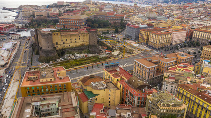 Fototapeta premium Aerial view of Castel Nuovo often called Maschio Angioino, a medieval castle located on the seafront, in the historic center of Naples, Italy. It was a royal seat for the kings of Naples and Aragon.