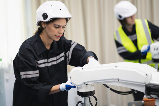 Engineer caucasian woman checking arm robot in the machine lap 