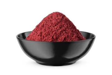 Dry ground sumac in black bowl isolated on white. Front view.