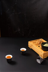 Женщина в черном кимоно проводит чайную церемонию