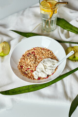 Morning granola breakfast with greek yougurt and glass of detox water with lemon, Homemade oatmeal granola, healthy food.