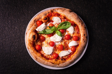 top view pizza with buffalo mozzarella and cherry tomatoes on a dark background
