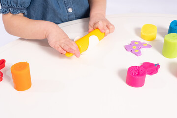 Beautiful girl plays and rolls plasticine