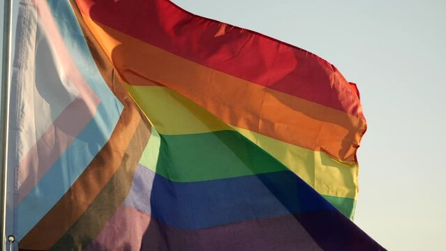 New LGBT Rainbow Pride Flag Waving. Rainbow flag is symbol Gay, Lesbian, Peace, Pride, LGBTQ, Bisexual, Homosexual, Transgender, Love. Rainbow flag waving on sunset, soft focus. Slow motion