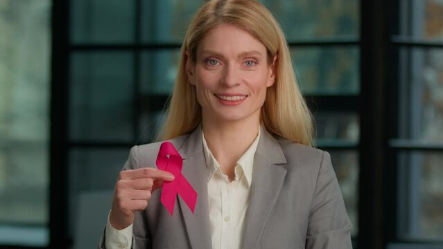 Headshot portrait Caucasian middle-aged woman hold red ribbon in office businesswoman with HIV AIDS awareness disease prevention protection sign volunteering activity charity. World breast cancer day - Powered by Adobe