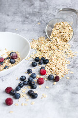 Oatmeal flaking with fresh blueberries, on a concrete background. healthy eating
