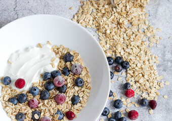 Oatmeal flaking with fresh blueberries, on a concrete background. healthy eating
