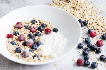 Oatmeal flaking with fresh blueberries, on a concrete background. healthy eating