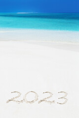 Fototapeta na wymiar Handwritting inscription numbers 2023 on perfect tropical sandy beach