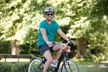 Obraz premium man with his bike enjoying driving in park