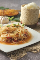 Papaya Salad, popular Thai food Served with grilled chicken, sticky rice and long beans.