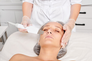 Beautician makes facial ultrasonic peeling for rejuvenation woman face skincare, anti aging...