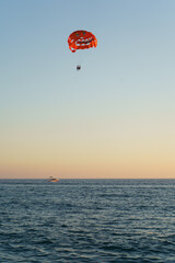 People Parasailing Over Sea Against Sky During Sunset
