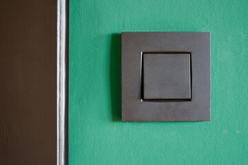 Close-up of a Black light switch on green wall
