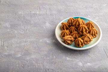 Homemade soft caramel fudge candies on gray concrete, side view, copy space.