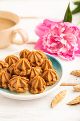 Homemade soft caramel fudge candies on gray concrete, side view, selective focus