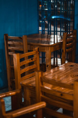 mesas de un pequeño bar con paredes azules y m,muebles de madera