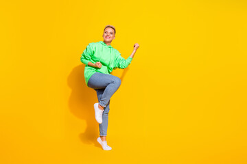 Fototapeta na wymiar Full length photo of overjoyed positive lady raise fists success attainment empty space isolated on yellow color background