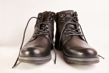 Black leather men's boots on a white background. Warm shoes for winter.