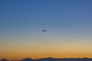 Fototapeta na wymiar Avion en phase d'atterrissage à l'aéroport de Nice Côte d'Azur dans le coucher de soleil