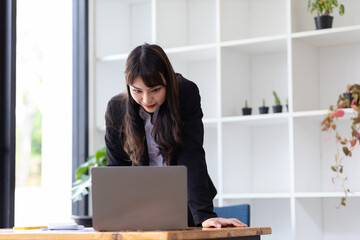 Portrait of a businesswoman holding a laptop working in the office.