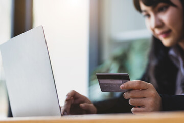 Woman holding credit card and using laptop. Online payment and online  shopping concept.