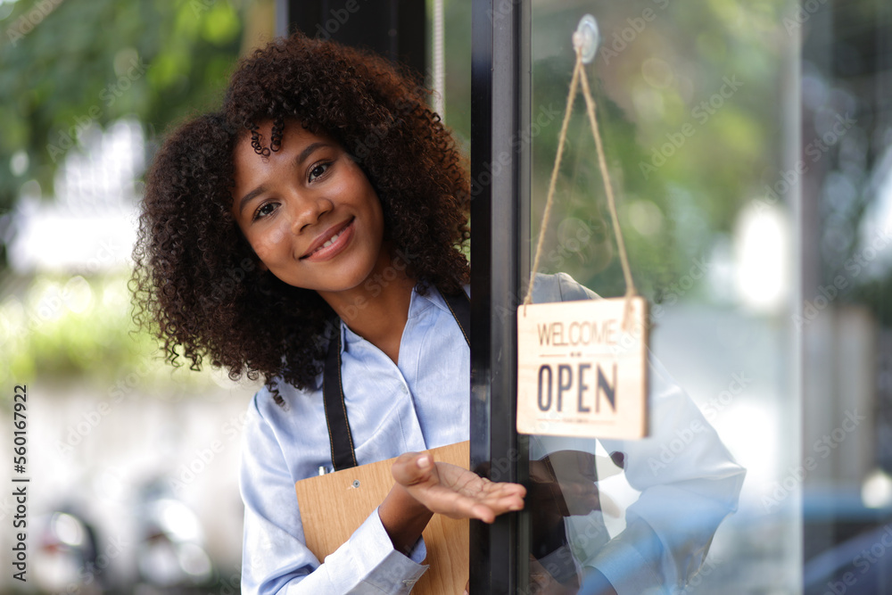 Wall mural young african woman small business start-up entrepreneur working in a cafe. employee working in a co