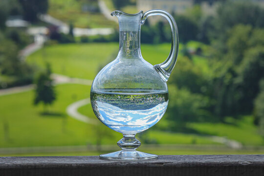 Wasserkrug gef&uuml;llt mit Wasser steht auf h&ouml;lzernem Gel&auml;nder