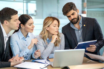 Group of business people discussing together important business document during the meeting in office