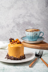 Caramel cake on a gray background. Chocolate and hazelnut cake with a cup of coffee. Bakery desserts. vertical view. close up