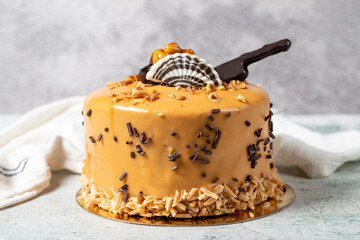 Caramel cake on a gray background. Chocolate and hazelnut birthday or celebration cake. Bakery desserts. close up