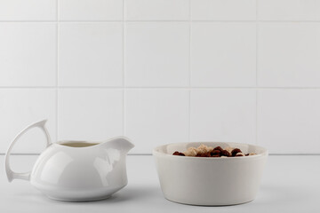 milk jar and corn flakes in a bowl on the table in kitchen