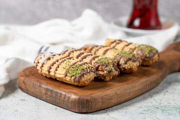 Chocolate, pistachio and coconut cookies on gray background. Bakery cookies assortment. Cookies with a cup of tea.Close up