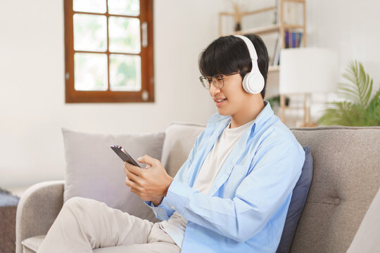 Business lifestyle, Businessman wears headphones to watching movie and listen music on smartphone