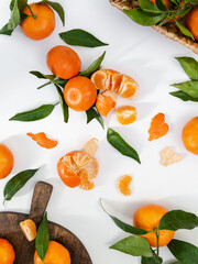 Composition from fresh ripe tangerines and leaves on white background