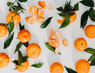 Composition from fresh ripe tangerines and leaves on white background