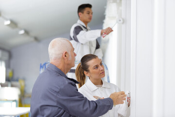 portrait of people painting wall in white