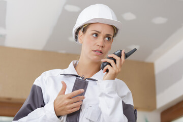 female construction worker using walkie-talkie