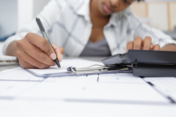 young businesswoman using calculator in the office