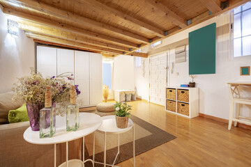 A loft apartment with pine wood paneling and white furniture on the ground floor